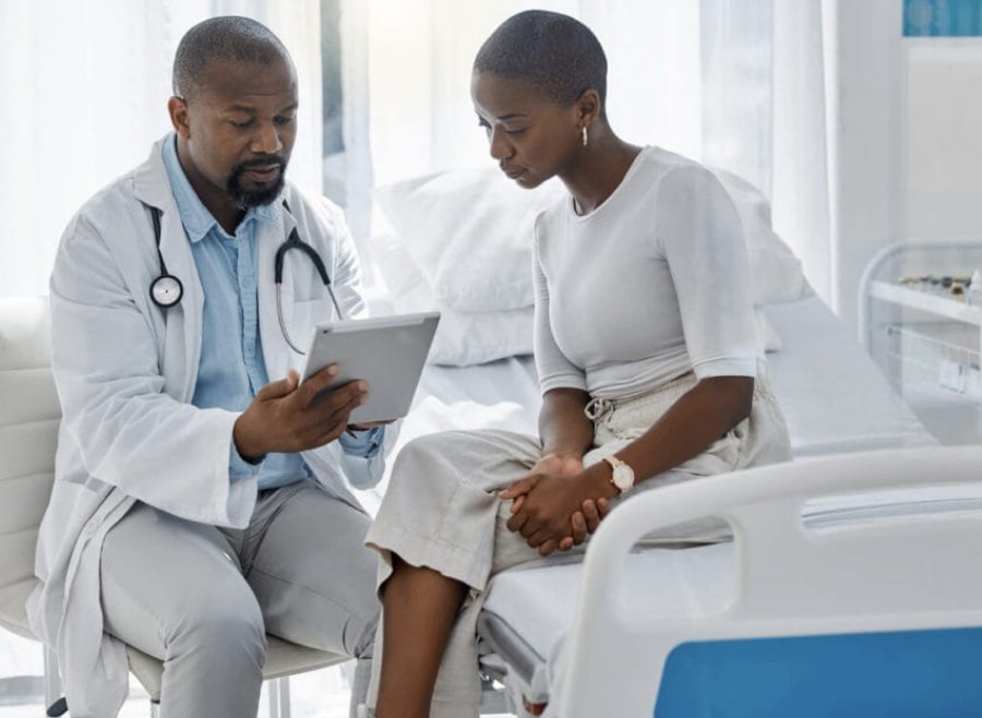A physician reviewing risk results on a tablet with a patient